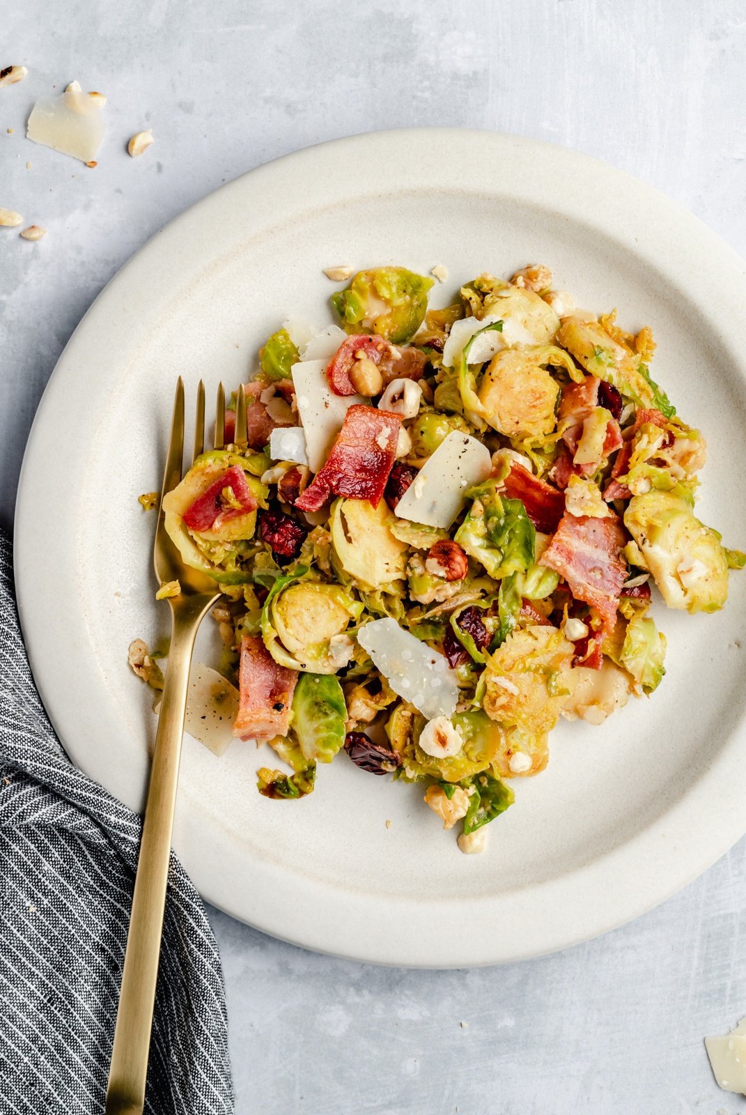 warm brussels sprouts salad with bacon on a plate with a fork